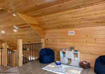 Cozy loft with wooden walls and seating area.